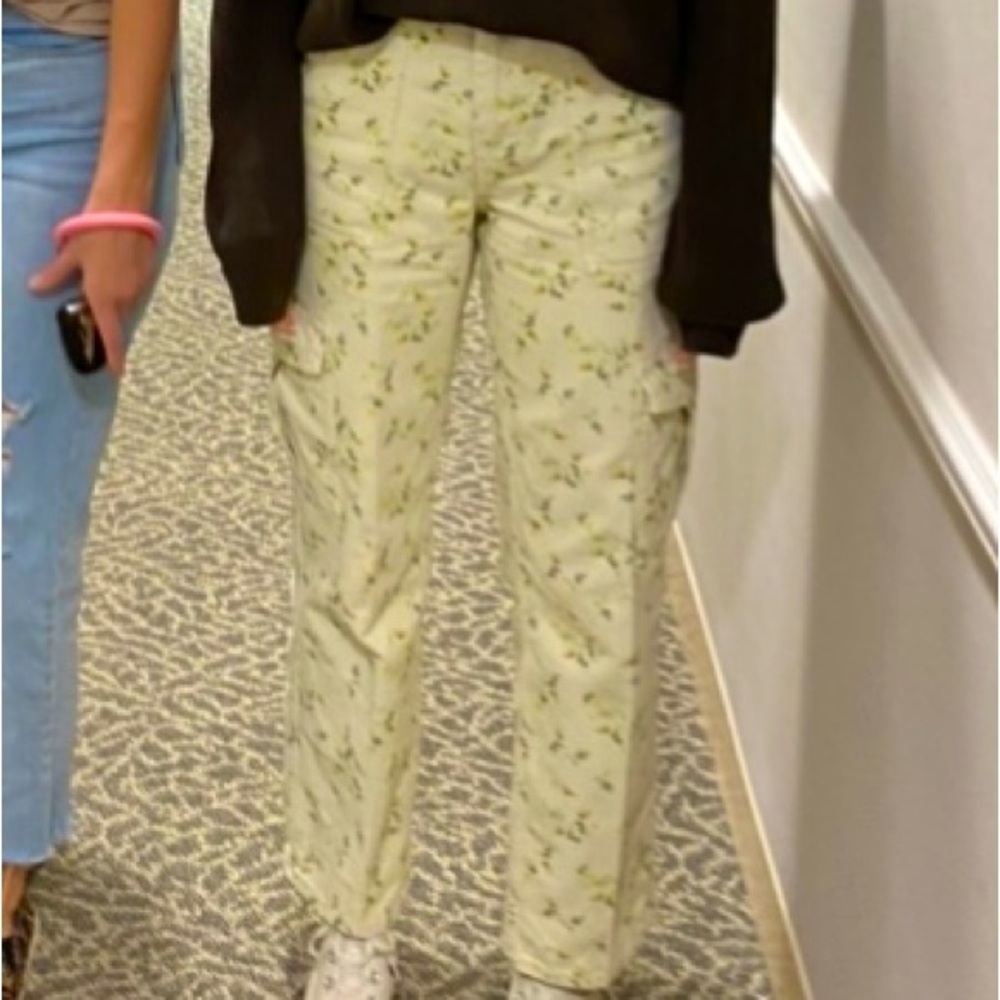 A pair of women’s white skater jeans with a simple floral design on them.